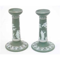 A pair of late 19th century Wedgwood Jasperware candlesticks, white moulded relief on a green gro...