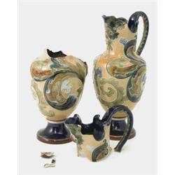 A pair of Doulton Lambeth jugs, with bird spouts and leaf scroll decoration, on beige grounds by...