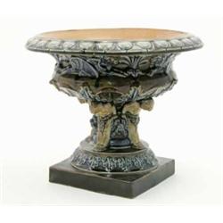 A Harriet Hibbert stoneware pedestal bowl, moulded with griffins and putti, on square base, 11ins...