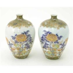 A pair of Japanese porcelain bottle vases, decorated with flowers behind a bamboo fence, 8.5ins...