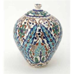 An Isnik pottery vase and cover, with stylised floral decoration, 11ins...