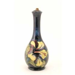 A Moorcroft Hibiscus pattern lamp, floral pattern on dark blue ground, impressed mark, remains of...