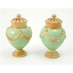 A pair of Royal Worcester pot pourri vases and covers, moulded with blushed floral swags against...