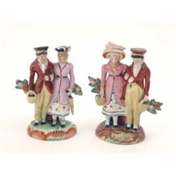 A pair of Victorian Staffordshire Dandy groups, each a couple, standing arm-in-arm, formally dres...
