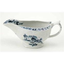 An early Lowestoft sauceboat, moulded with foliate cartouches and painted in underglaze blue with...