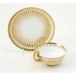 A 19th century moulded tea cup and saucer, probably Swansea, with raised handle and gilded decora...