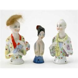 A pair of German porcelain tea-cosy busts, ladies with natural hair, 3.5ins (one wig missing) and...