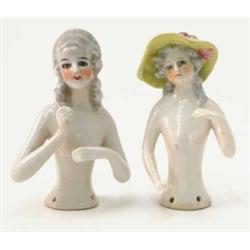 Two German porcelain tea-cosy busts, each topless, one wearing yellow hat, 3.5ins...