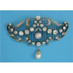 A late Victorian brooch, designed as diamond set scrolls and swags on knife-edge bars with cultur...