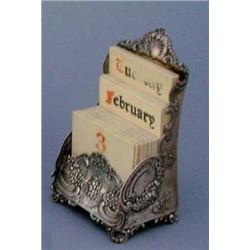 A Tiffany & Co desk calendar, with embossed floral design, showing day, month and date on ivory i...