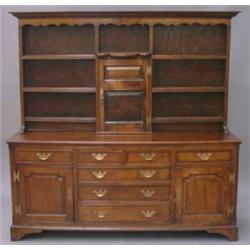 A George III oak dresser, the upper part having moulded and shaped cornice, over central fielded...