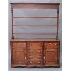 A George III oak dresser, the plate rack having moulded cornice over three shelves, the breakfron...