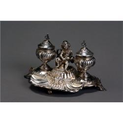 German Rococo Style Silver Figural Standish, Circa 1900, Depicting a putto holding a caduceus...