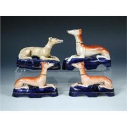 A pair and two other Staffordshire greyhound inkwells, each of the salmon brown animals reclining o.