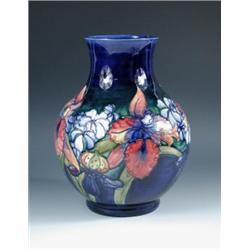 A mid 20th century Moorcroft vase, the baluster shape slip trailed and painted with pink irises amo.
