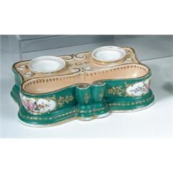A mid 19th century Paris porcelain inkstand, the gilt salmon ground top with pen trough before two..