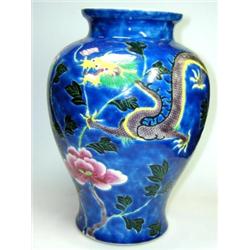 A 19th century Chinese vase, the baluster shape painted with a phoenix and dragon flying above pink.