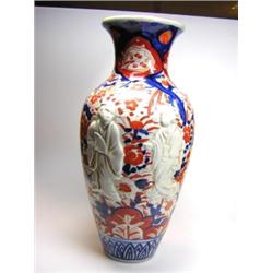 An early 20th century Japanese Imari vase, the baluster shape moulded in low relief with white figu.