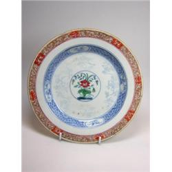 An early 18th century Chinese famille verte plate, the central floral roundel enclosed by pencilled.