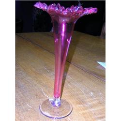 A pair of late 19th century cranberry vases, the serrated rims crimped above trumpet bodies and cle.