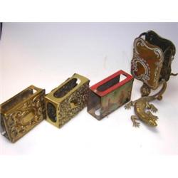 Four various match box sleeves, one of brass engraved with rococo cartouches and supported on the b.