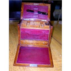 An early 20th century oak stationery box, the rectangular lid releasing the fall front writing slop.