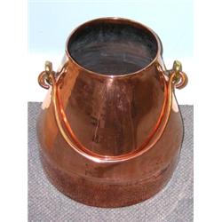 A 20th century copper churn, the sides flaring to a cylindrical base and overswung by a handle with.