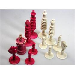 A late 19th century red and white bone chess set, possibly Indian, each piece with ring turned deco.