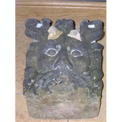 A 19th century millstone grit 'green man' gargoyle, the foliate mask front with gargoyle mouth at r.