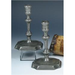 A pair of mid 18th century pewter candlesticks, the triple ring turned nozzles on baluster stems and