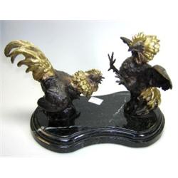 A 20th century bronze group of fighting cocks, their heads and tails polished and their bodies dark.