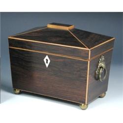 An early 19th century rosewood tea caddy, the corners of the sarcophagus shape lined in boxwood, th.