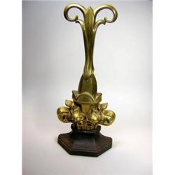A late Victorian brass door stop cast with a fleur de lys above the facetted iron base, the stem di.