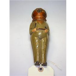 A Bing painted tin model of a diver, wearing helmet and weighted boots, holding knife and axe, 21cm.
