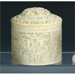 A Chinese ivory cylindrical box and cover carved in low relief with flowers on the domed lid and wi.