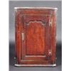 A George III oak hanging corner cupboard, the moulded cornice above an arch panelled door enclosing.