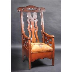 A 19th century oak armchair, possibly American, the pierced arched top rail above a scroll pierced..
