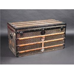 A Louis Vuitton trunk, the banded rectangular rising top enclosing a fitted interior above a simila.