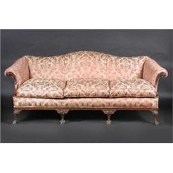 A George III style mahogany framed settee, the arched padded back above padded scrolling arms and c.
