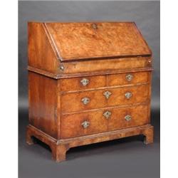 An early 18th century walnut bureau, the feather banded rectangular top above a similarly banded fa.