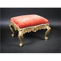 A 19th century giltwood framed stool, the shaped overstuffed seat above a scrolling carved apron su.