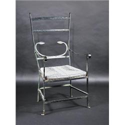 A Regency wrought iron open armchair, the finial mounted arched top rail above a conforming rail, s.