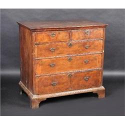 An early 18th century walnut chest, the crossbanded moulded rectangular top above two short and thr.