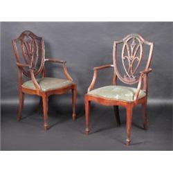 A set of four George III style mahogany dining chairs, including two carvers, each with shield shap.