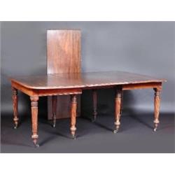 A Regency mahogany extending dining table, the moulded rounded rectangular top incorporating two le.