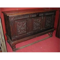 A carved oak coffer on stand, the moulded rectangular rising top above a carved frieze and carved t.