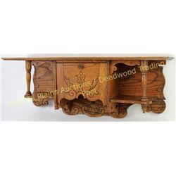 Antique oak clock wall shelf with center compartment, shelf shows original finish, 26" long.  Est. 5