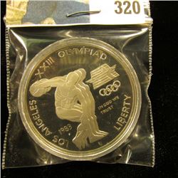 1983 S U.S. Olympics Proof Silver Dollar, Discus thrower, encapsulated.