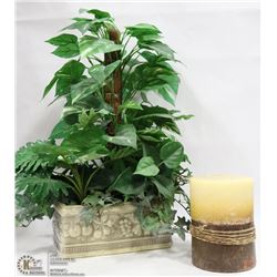 SILK PLANT AND LARGE CANDLE.