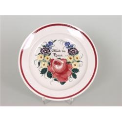 Drei Teller. Steingut. Im Spiegel farbiges Blumenbukett und Inschrift: "Glück im Haus". Pressmark...